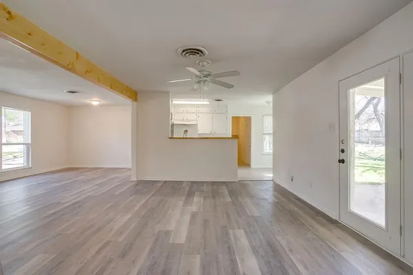 a view of an empty room with a fireplace and a window