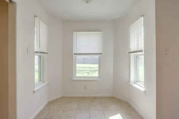 an empty room with a window and a fan