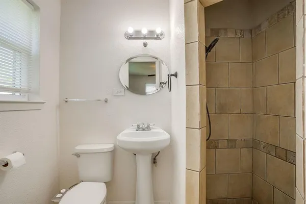 an empty room with a chandelier fan and windows