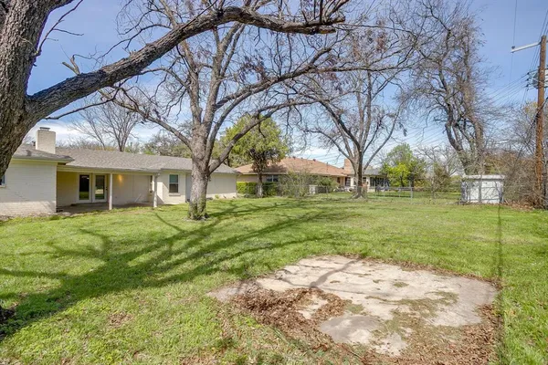 a view of a yard in front of a house with large trees