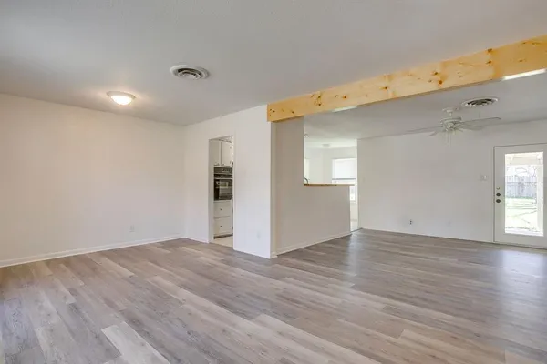 an empty room with wooden floor and a fireplace