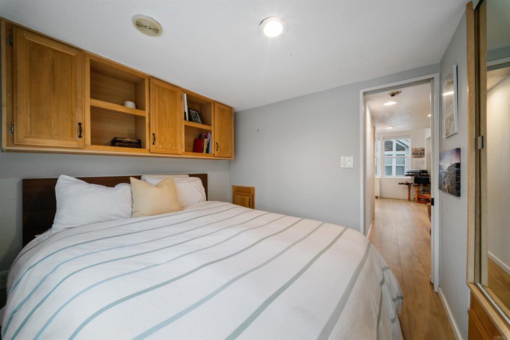 1624 North Coast Highway 101, Unit 45 Encinitas, CA 92024 - Photo 21 of 37 a bedroom with a bed and a view of living room