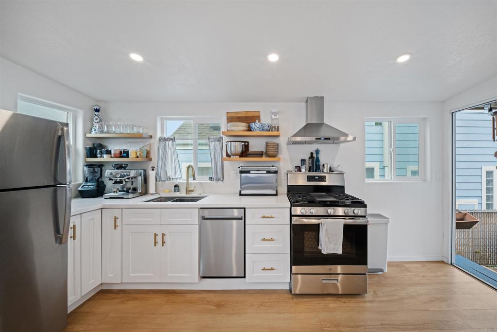 1624 North Coast Highway 101, Unit 45 Encinitas, CA 92024 - Photo 7 of 37 a kitchen with stainless steel appliances granite countertop a stove and a refrigerator