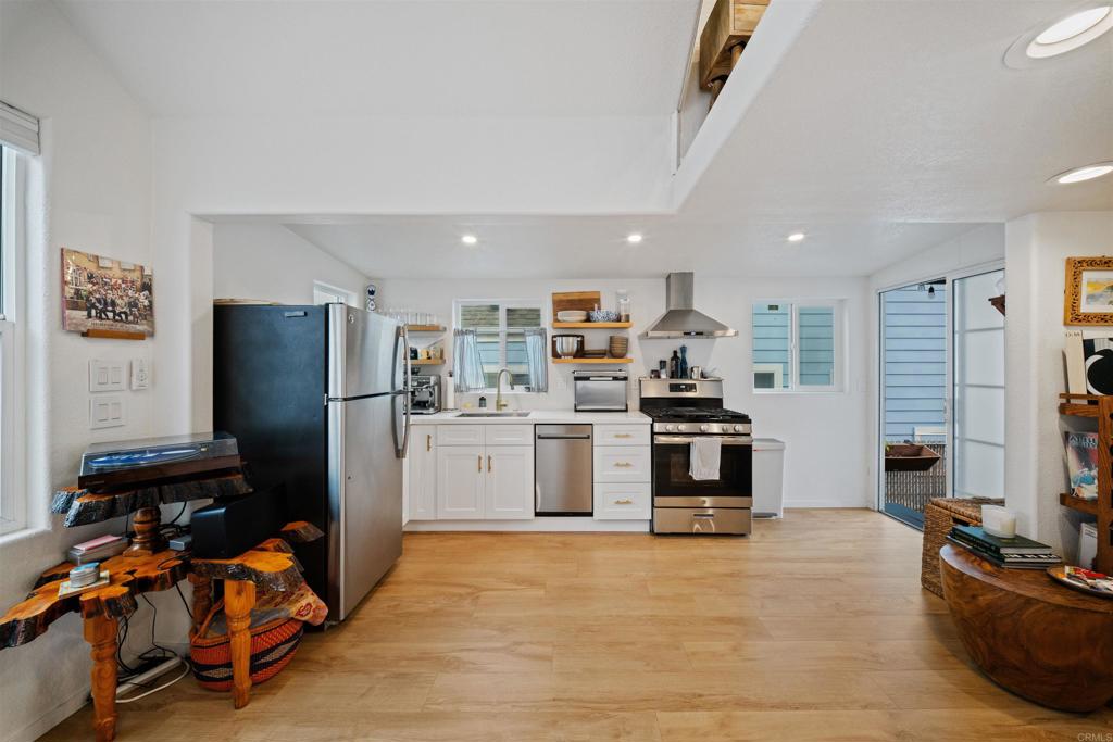 1624 North Coast Highway 101, Unit 45 Encinitas, CA 92024 - Photo 8 of 37 a kitchen with stainless steel appliances kitchen island a refrigerator sink and stove