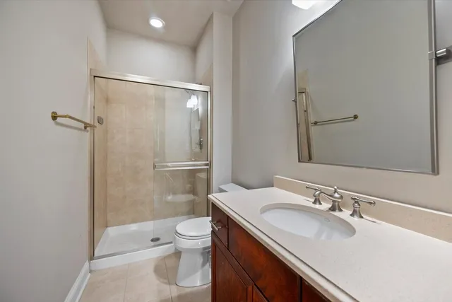 a bathroom with a sink toilet double vanity and shower