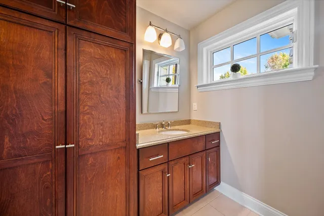 a bathroom with a granite countertop sink a toilet and a mirror