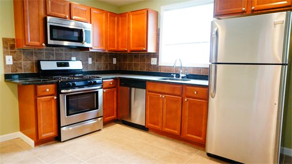 a kitchen with stainless steel appliances granite countertop a stove microwave refrigerator and sink