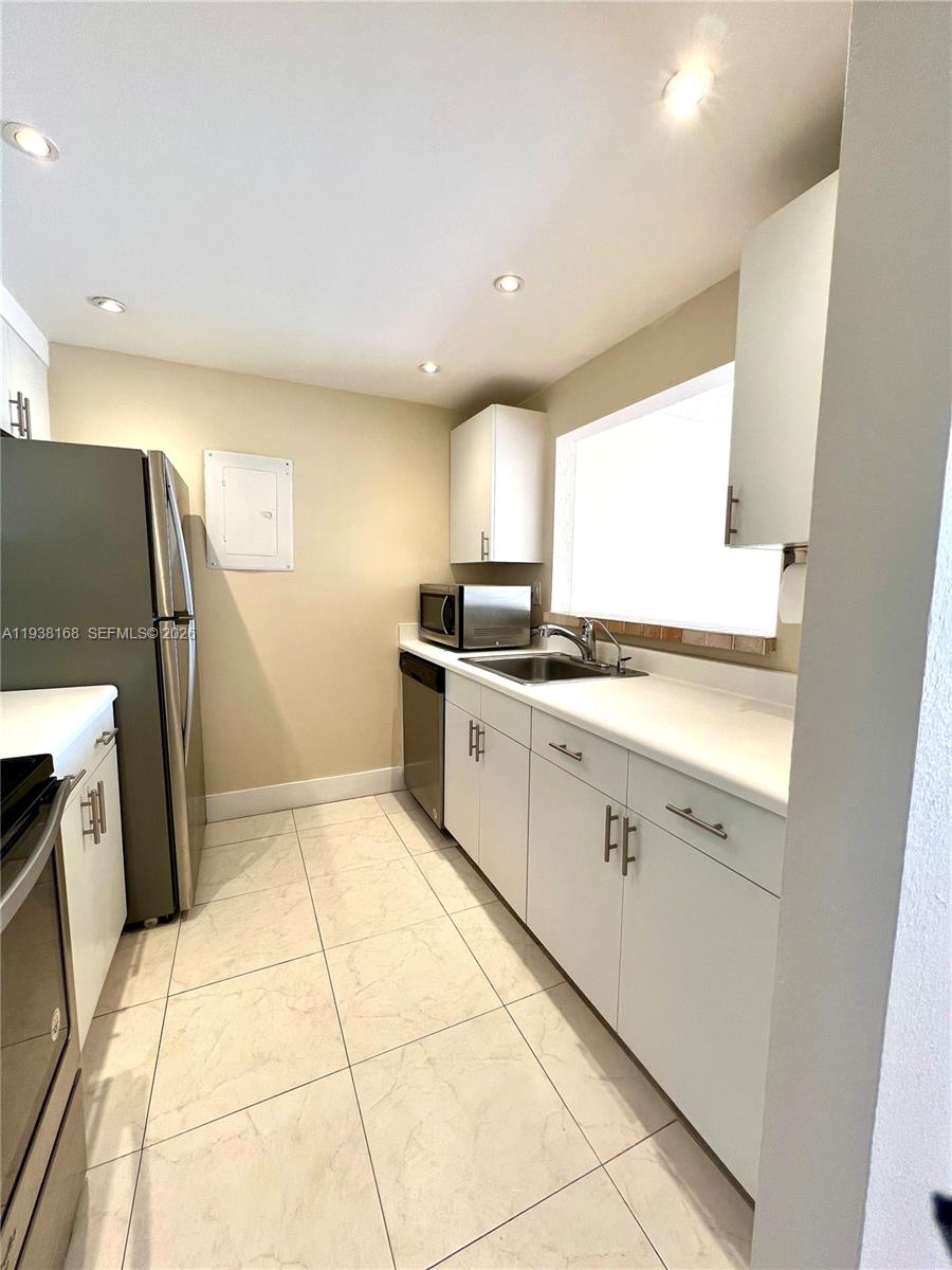 2160 Southwest 16th Avenue, Unit 314 Miami, FL 33145 - Photo 4 of 15 a kitchen with a sink a refrigerator and window