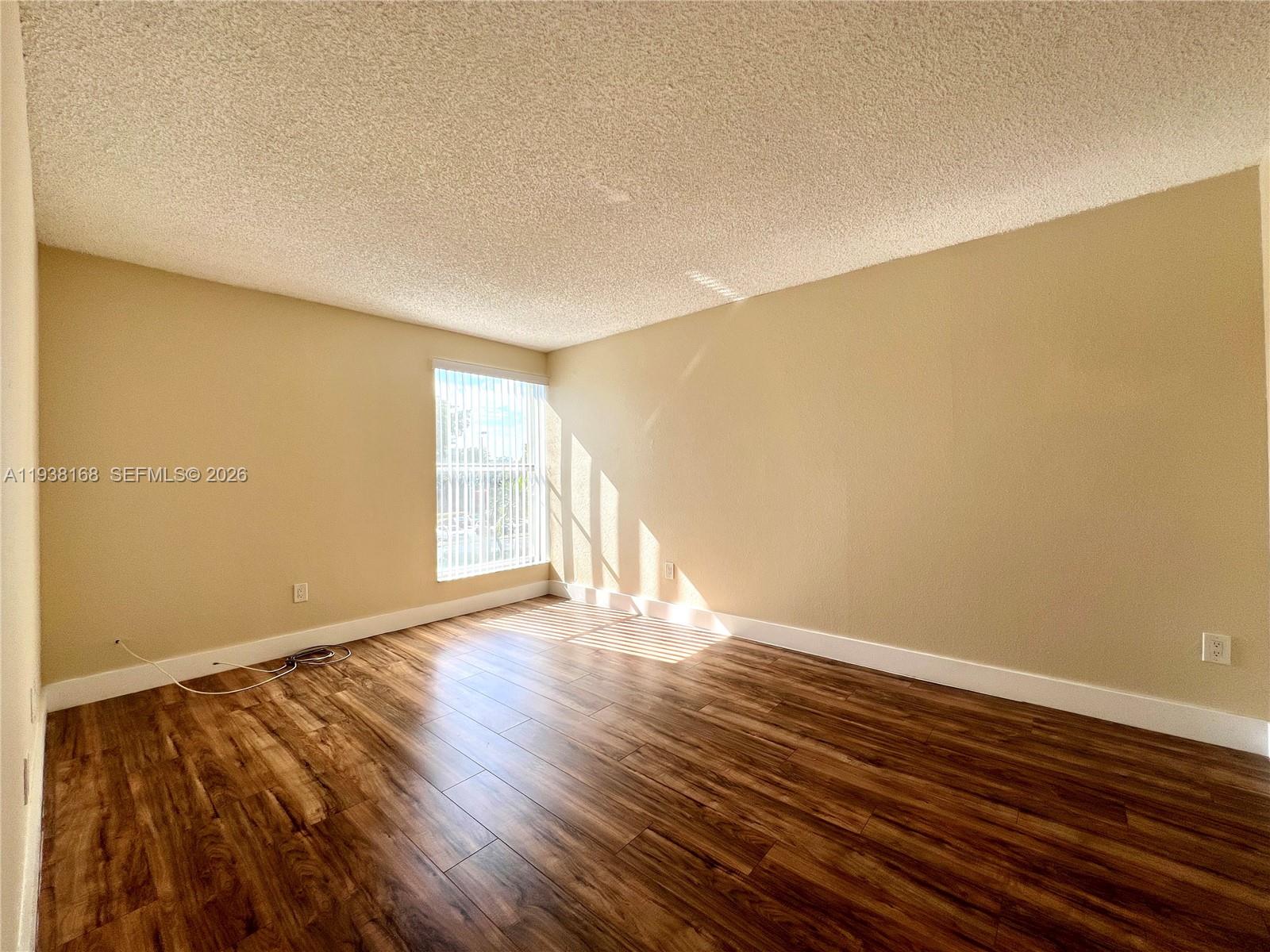 2160 Southwest 16th Avenue, Unit 314 Miami, FL 33145 - Photo 8 of 15 a view of an empty room with wooden floor and a window