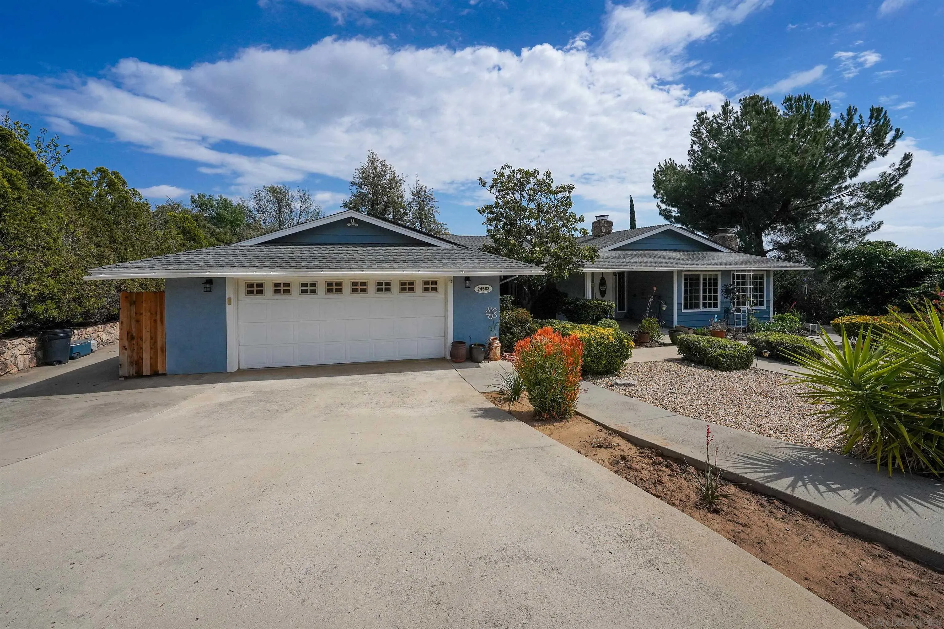 24563 Del Amo Road Ramona, CA 92065 - Photo 49 of 59 a front view of a house with a yard and table and chairs under an umbrella