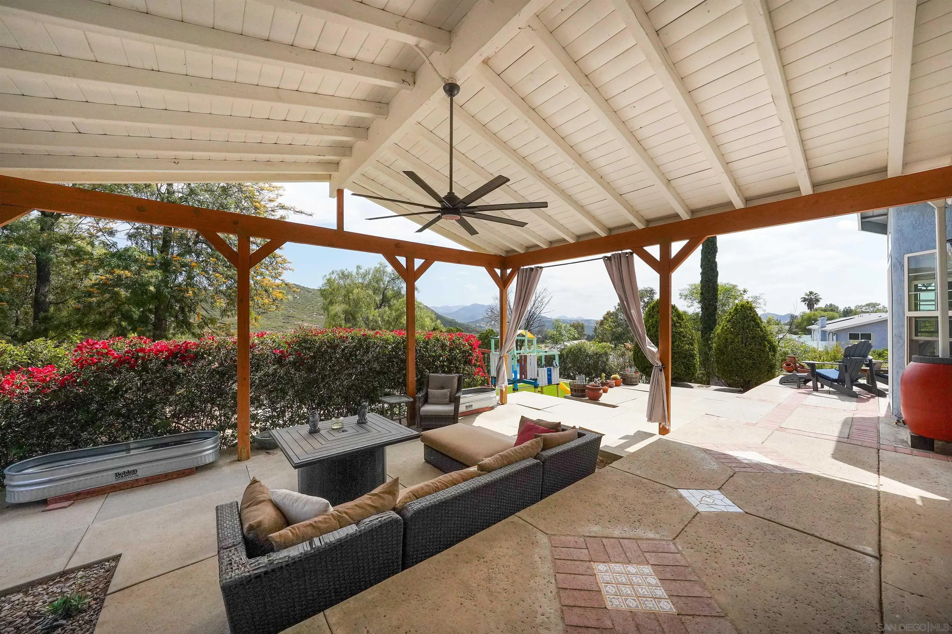 24563 Del Amo Road Ramona, CA 92065 - Photo 50 of 59 a view of a patio with a table chairs potted plants and a palm tree