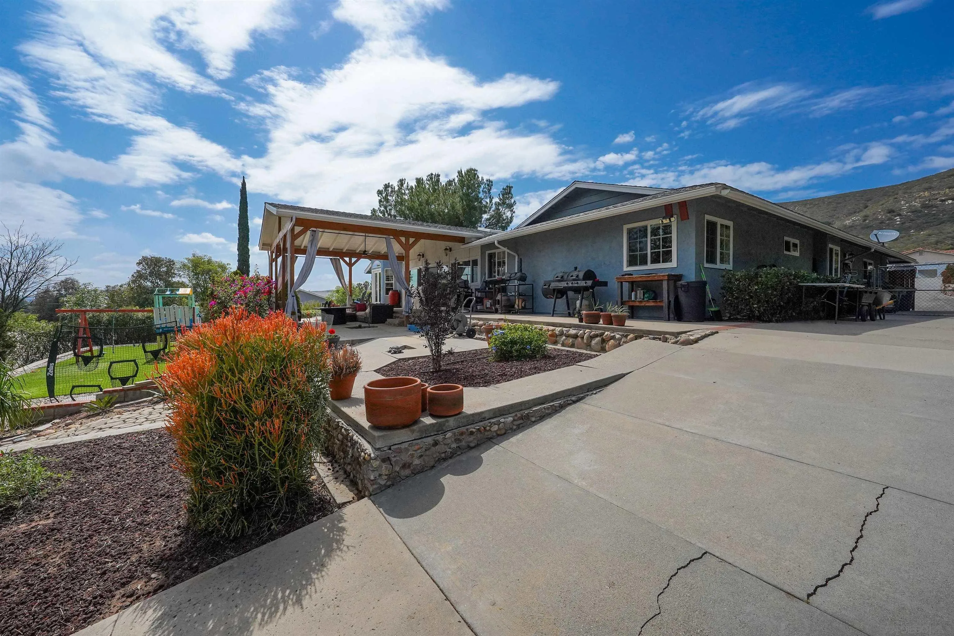 24563 Del Amo Road Ramona, CA 92065 - Photo 53 of 59 a front view of a house with patio furniture and a fire pit