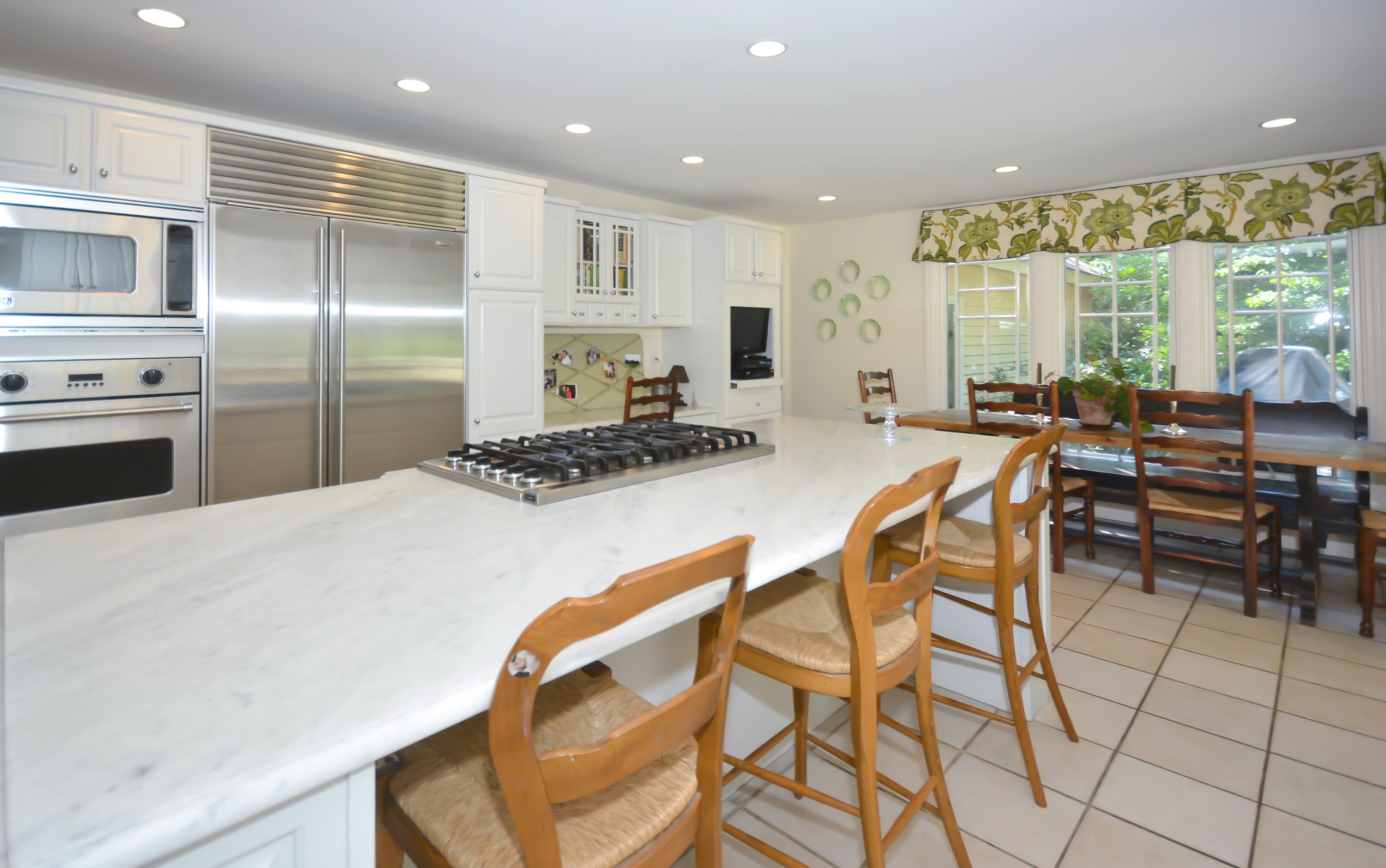 47 Delafield Island Road Darien, CT 06820 - Photo 12 of 26 a kitchen with stainless steel appliances kitchen island granite countertop a stove a refrigerator a table and chairs in it