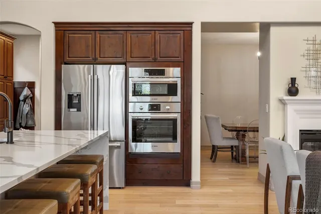 a kitchen with granite countertop a refrigerator and a stove top oven