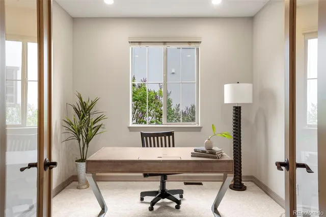 a view of a workspace with furniture and a window