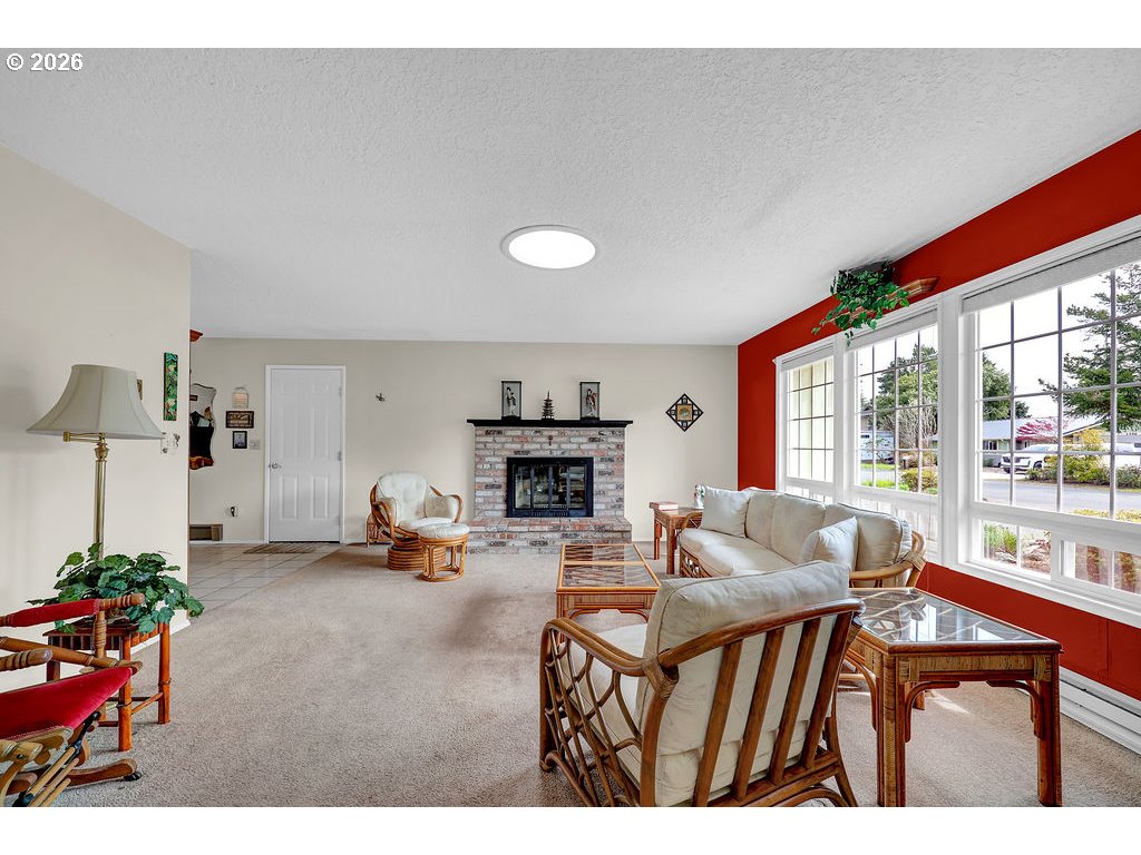 1415 20th Street Florence, OR 97439 - Photo 7 of 40 a living room with furniture a fireplace and a large window