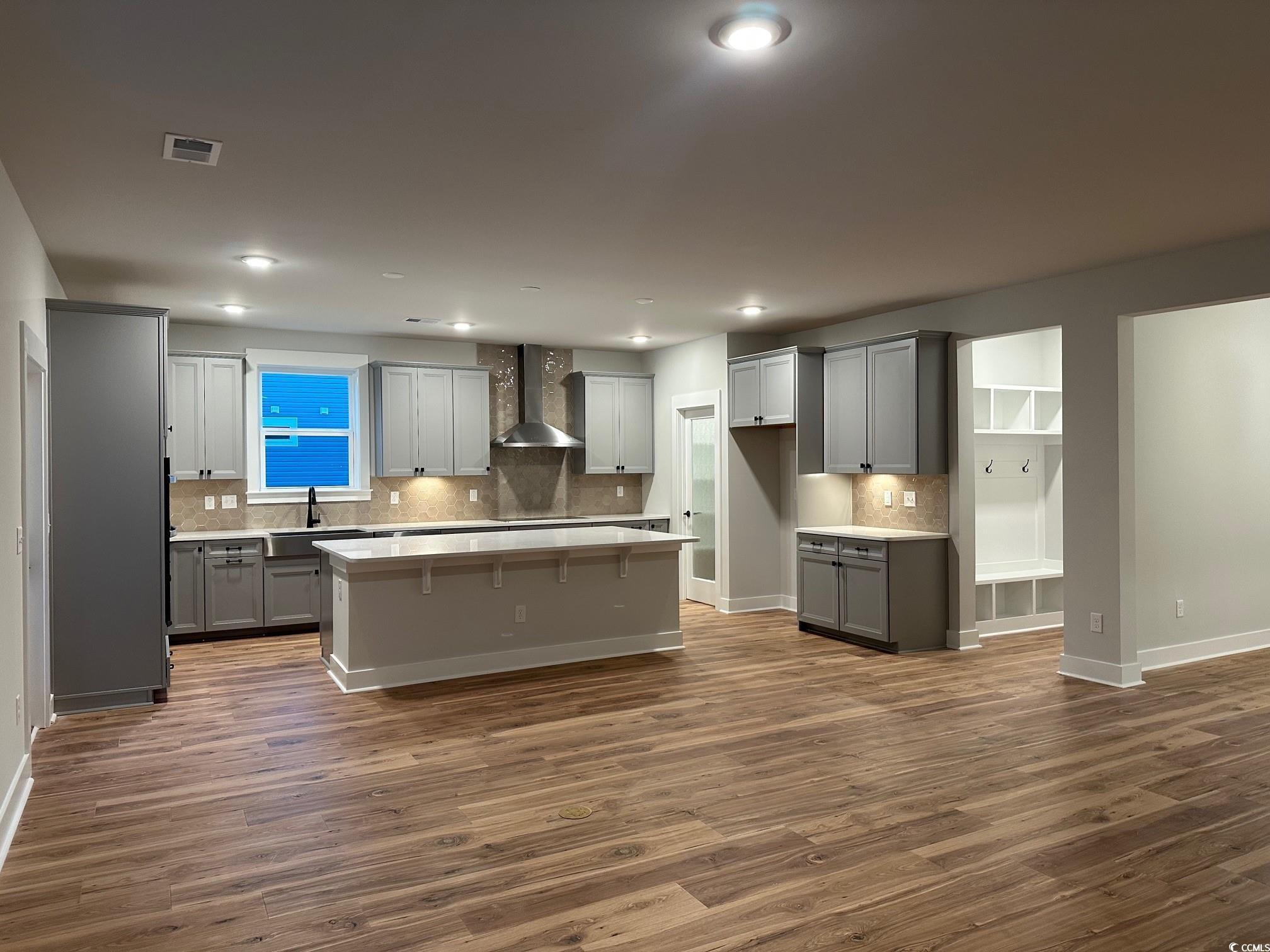 85 Northbrook Drive Murrells Inlet, SC 29576 - Photo 10 of 34 Kitchen featuring gray cabinets, a kitchen island, wall chimney range hood, dark wood-style flooring, and recessed lighting