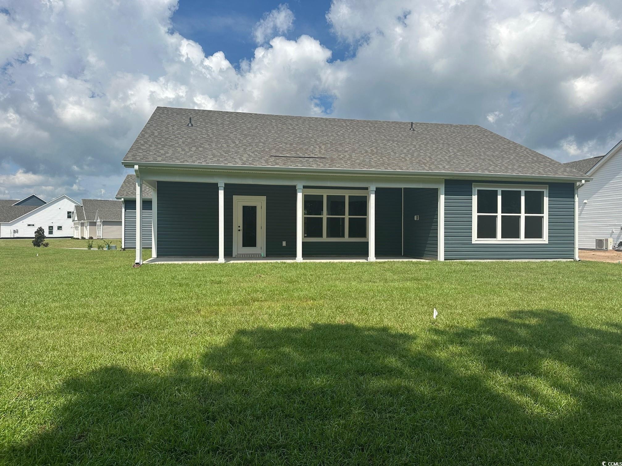 85 Northbrook Drive Murrells Inlet, SC 29576 - Photo 24 of 34 Rear view of house featuring a shingled roof, a patio, and a lawn