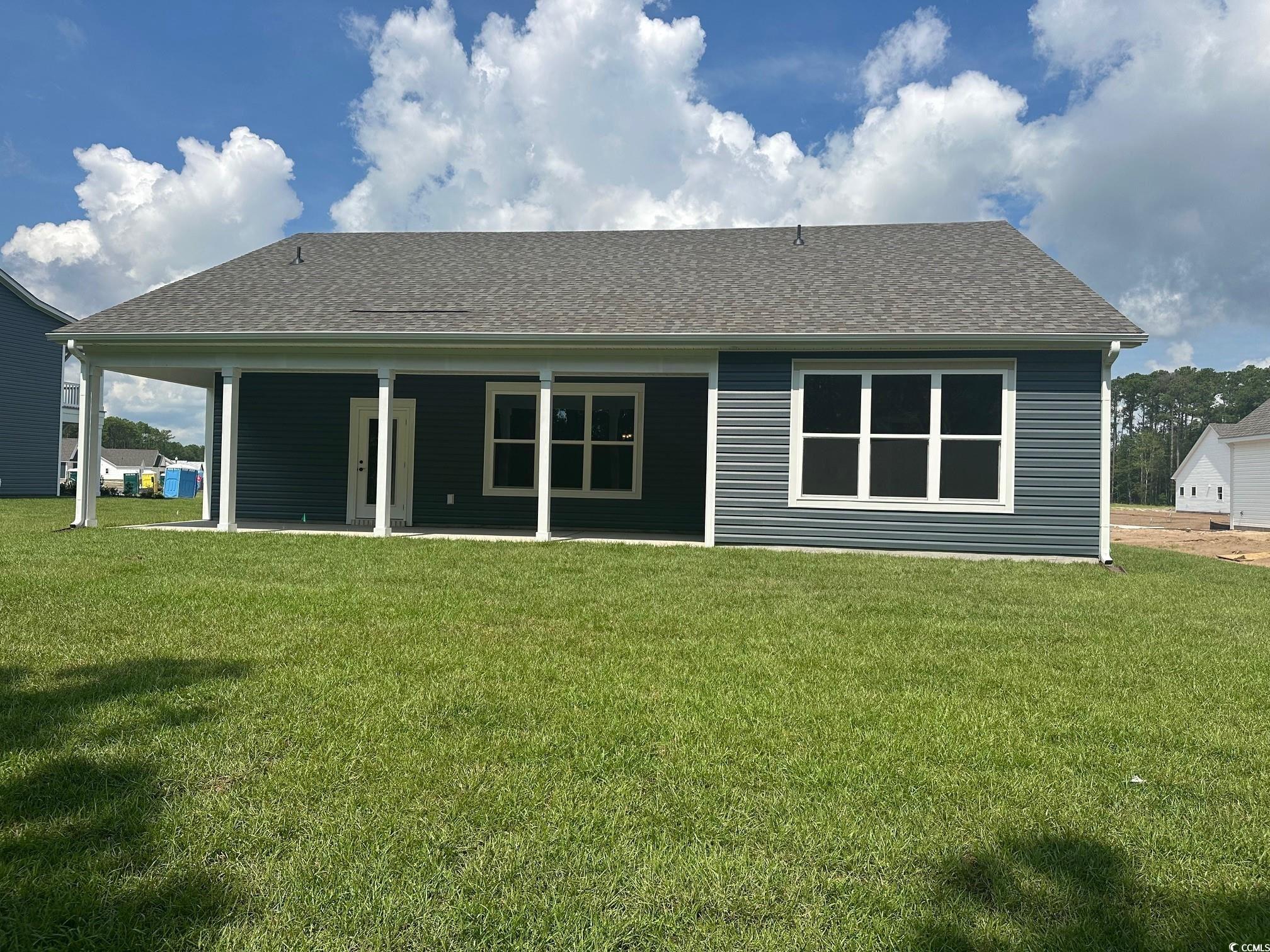 85 Northbrook Drive Murrells Inlet, SC 29576 - Photo 25 of 34 Back of property with a yard, roof with shingles, and a patio area