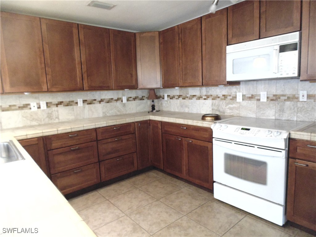 18215 Iris Road Fort Myers, FL 33967 - Photo 6 of 34 a kitchen with a sink and a stove top oven