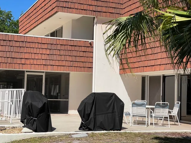 a view of a house with backyard and sitting area