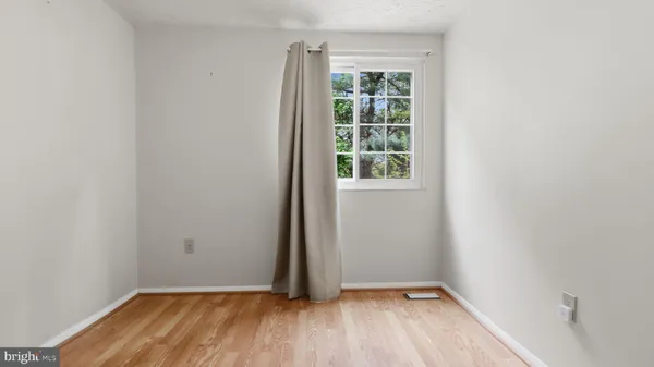 a view of empty room with wooden floor