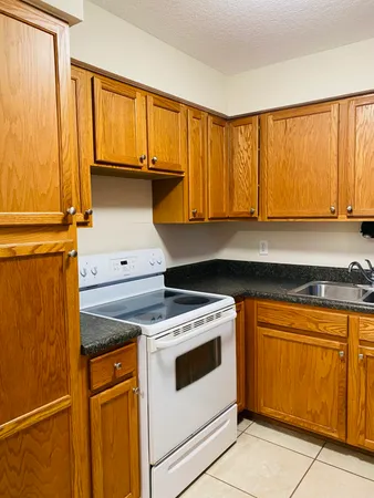 a kitchen with granite countertop cabinets stainless steel appliances and a counter space