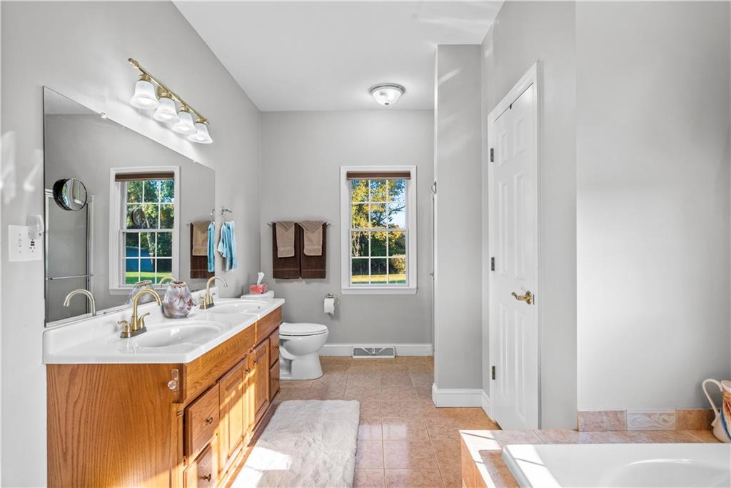 747 Achortown Road Beaver Falls, PA 15010 - Photo 14 of 28 a spacious bathroom with a double vanity sink a mirror and a bathtub