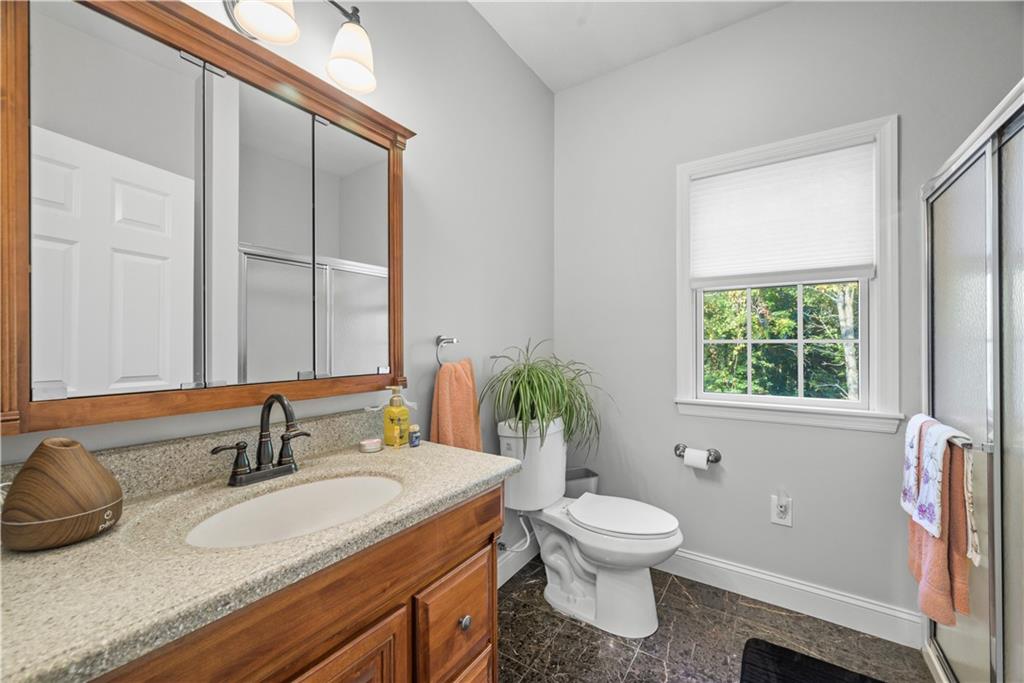 747 Achortown Road Beaver Falls, PA 15010 - Photo 17 of 28 a bathroom with a granite countertop sink toilet a large mirror and a window