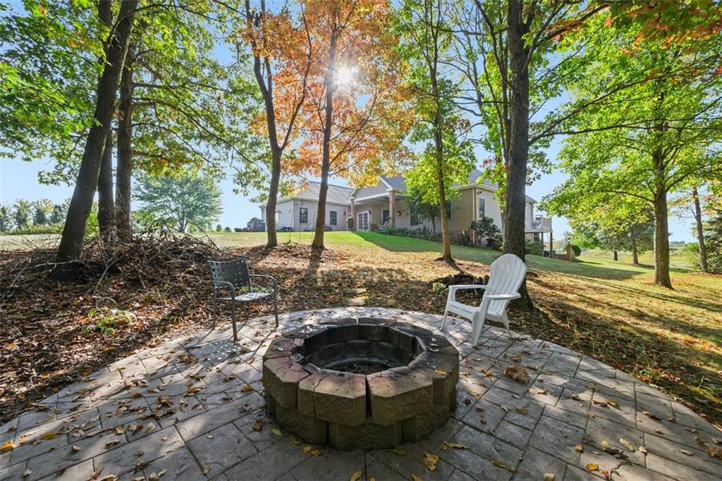 747 Achortown Road Beaver Falls, PA 15010 - Photo 26 of 28 a view of a backyard with table and chairs and a barbeque with wooden fence and large trees