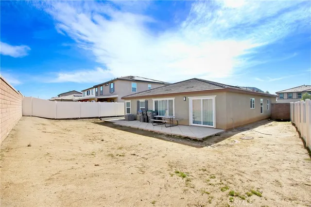 a big house with wooden fence next to a yard