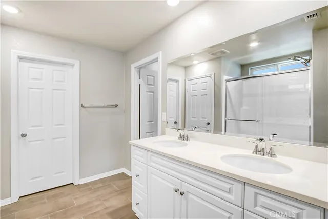 a bathroom with double sink and a mirror