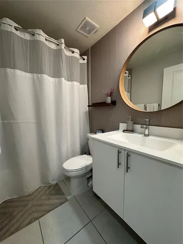 a bathroom with a sink mirror vanity and toilet