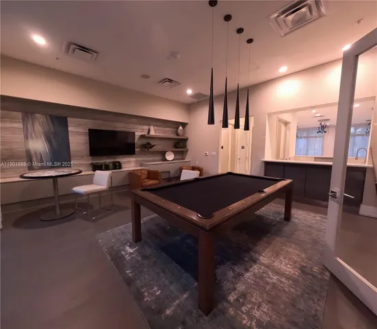 a living room with furniture pool table and flat screen tv