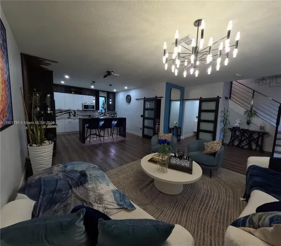 a view of a dining room with furniture a chandelier and wooden floor