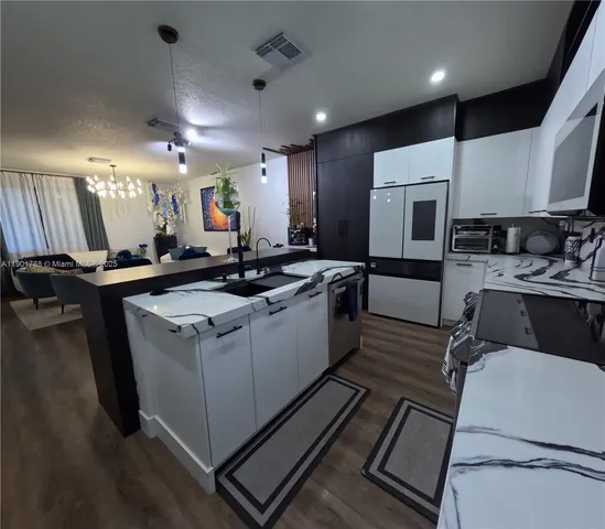 a kitchen that has a sink a stove and chairs
