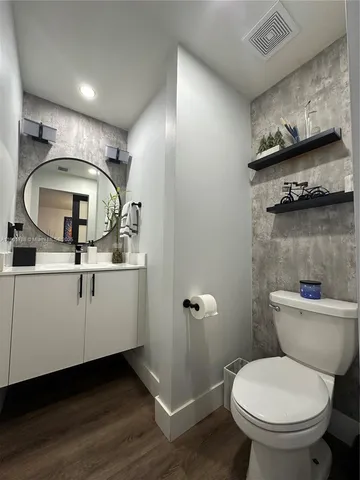 a bathroom with a toilet sink and mirror
