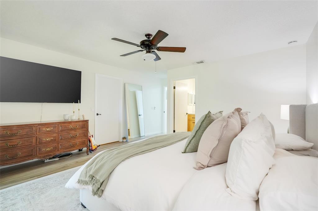 30024 Tavares Ridge Boulevard, Unit 62 Tavares, FL 32778 - Photo 16 of 31 a bedroom with a bed and a flat screen tv