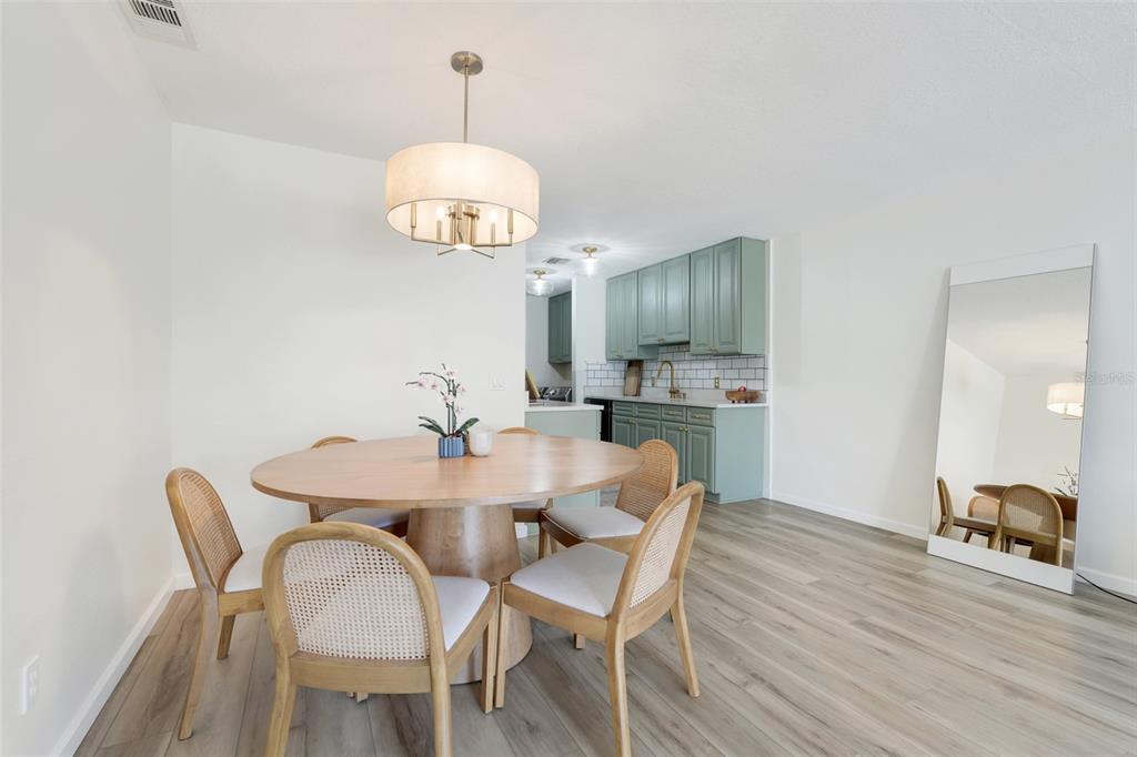 30024 Tavares Ridge Boulevard, Unit 62 Tavares, FL 32778 - Photo 8 of 31 a view of a dining room with furniture wooden floor and chandelier