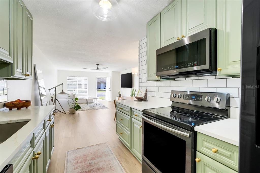 30024 Tavares Ridge Boulevard, Unit 62 Tavares, FL 32778 - Photo 9 of 31 a kitchen with a stove and a flat screen tv