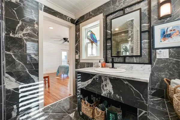 a bathroom with a sink a toilet a mirror and shower