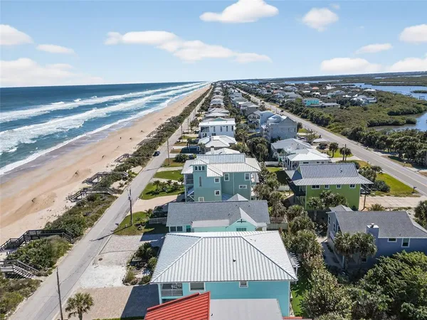 an aerial view of a city with lots of residential buildings and ocean view in back