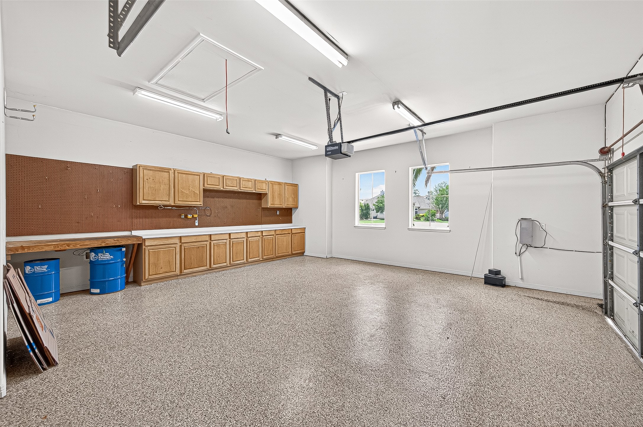 25626 Windy Isle Court Spring, TX 77389 - Photo 34 of 45 Spacious, well-lit two- car garage with durable flooring, ample storage cabinets, a workbench, and two windows for natural light.