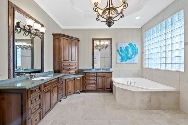 a bathroom with a double vanity sink a bathtub a mirror and a bathtub