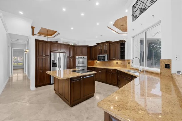 a kitchen with stainless steel appliances granite countertop a sink and a refrigerator