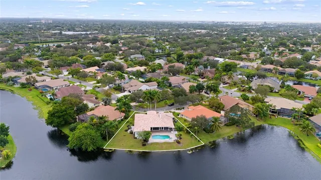 an aerial view of residential houses with outdoor space and trees