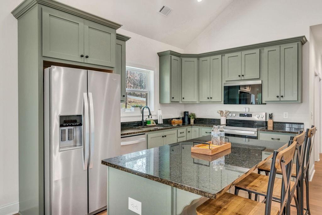 246 Woodward Way Talking Rock, GA 30175 - Photo 13 of 39 a kitchen with stainless steel appliances granite countertop a refrigerator a stove top oven a sink and dishwasher