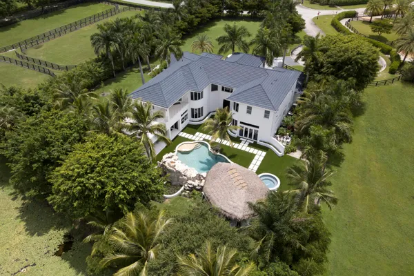 an aerial view of a house with swimming pool and garden