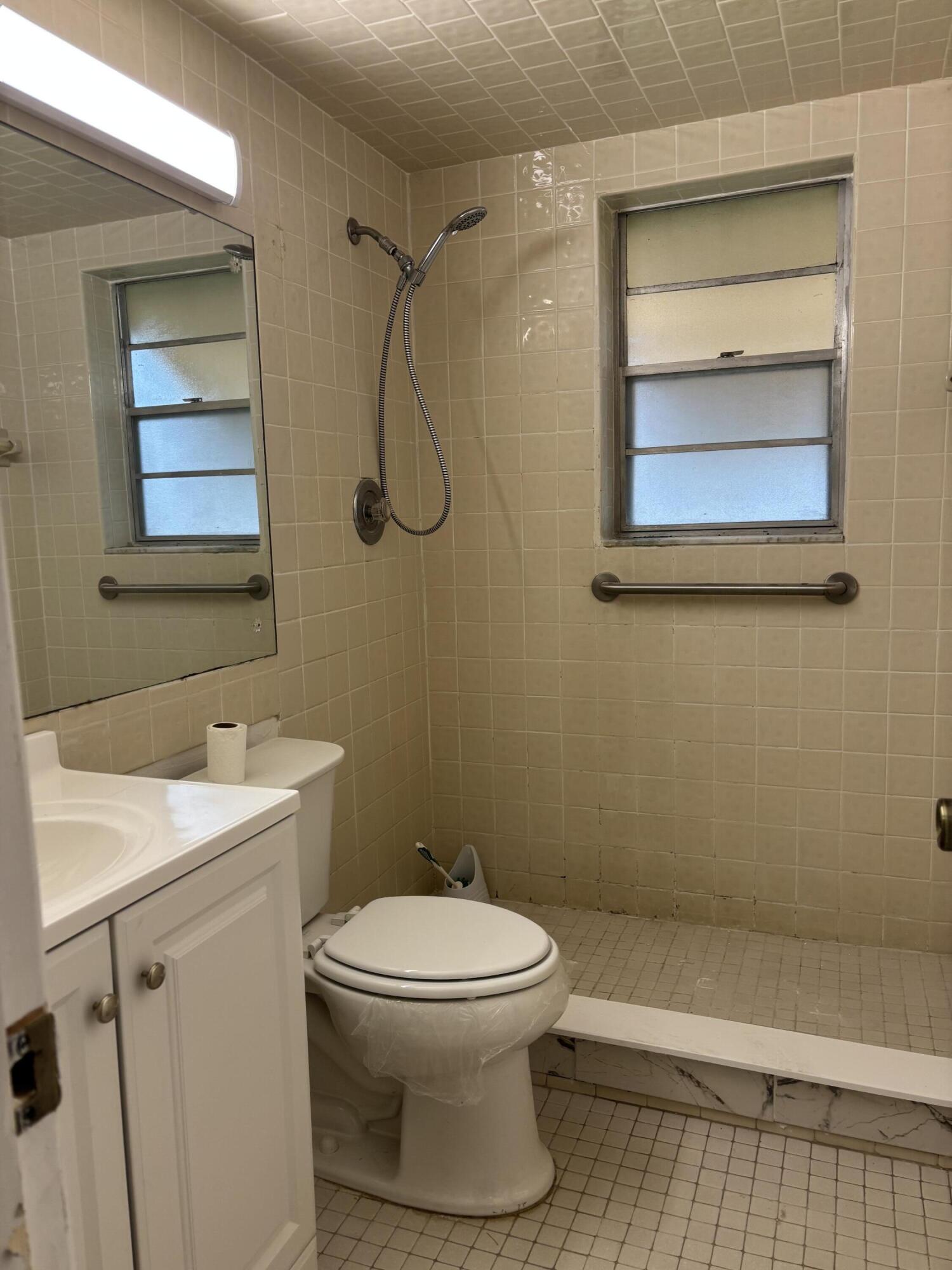 204 Salisbury I, Unit 204 West Palm Beach, FL 33417 - Photo 11 of 14 a bathroom with a toilet sink and shower