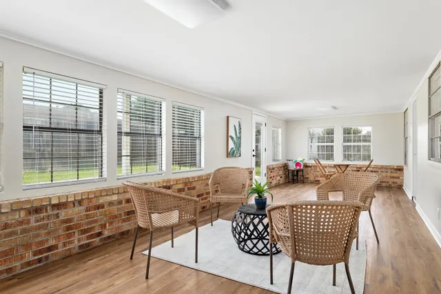 a living room with furniture and floor to ceiling windows